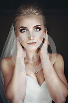 Beautiful innocent blonde bride with blue eyes posing, face closeup