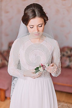 Beautiful innocent bride at home in white wedding dress, preparations concept. Portrait of tender girl in gown