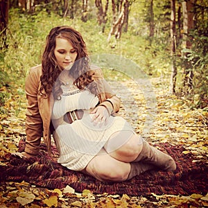 Beautiful instagram of pregnant woman sitting on forest path