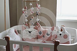 Beautiful interior of baby room with a crib. White crib with pillows and pink blanket in baby room. pastel pink bedding