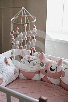 Beautiful interior of baby room with a crib. White crib with pillows and pink blanket in baby room. pastel pink bedding