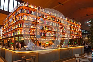 Beautiful interior bar counter covered with illuminated alcohol bottles
