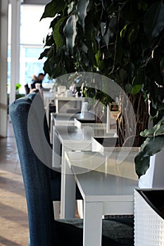 Beautiful interior of the cafe Clowns in Novosibirsk with white tables and chairs with modern dining room