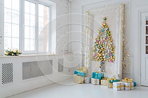 Beautiful interior living room decorated for Christmas. Big mirror frame with a tree made of balls and toys