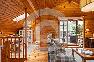 Beautiful interior of a living room with view of terrace and dining area in a wooden house