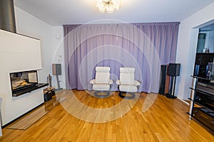 Beautiful interior view of modern decorated room in private home. White fire place.