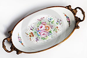 Beautiful Italian porcelain dish decorated with with flowers and gold isolated on white background.