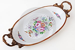 Beautiful Italian porcelain dish decorated with with flowers and gold isolated on white background.