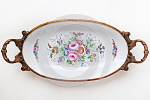 Beautiful Italian porcelain dish decorated with with flowers and gold isolated on white background.