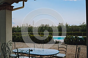 Beautiful Italian-style terrace in a field with olive fields in the background. Comfort and relaxation, boho style