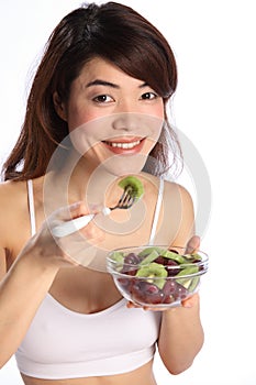 Beautiful japanese girl eating healthy fruit salad