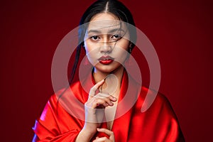 Beautiful Japanese Girl in Red Silk Kimono Dress. Asian Beauty Woman Face with Red Lips Makeup. Chinese Fashion Model showing