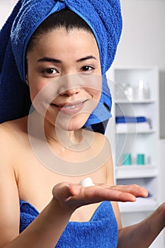 Beautiful japanese woman with moisturiser in hand