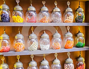 beautiful jars full of colorful delicious dessert Turkish delight, on a orange background. Turkish sweets shop