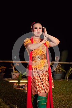 Beautiful Javanese woman with a golden necklace on her neck and golden belt on a yellow dress on their body