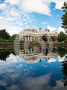 Beautiful Jefferson Monticello mansion reflecting in pool with clouds hanging above on sunny day