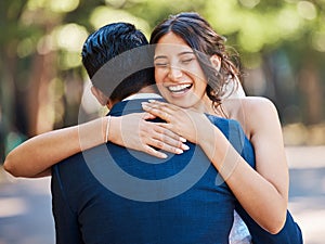 Beautiful joyful bride embracing her husband. Happy newlywed couple hugging and looking happy on their wedding day