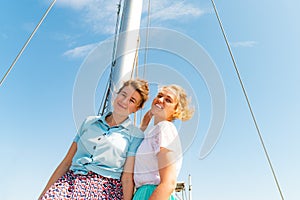 Beautiful and joyful girls, smiling friends, on the deck of a yacht