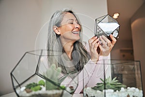 Beautiful joyful woman holding geometric glass succulent terrarium