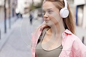 beautiful joyful young woman with headphones outdoors