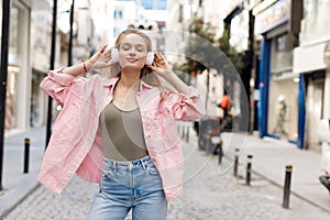 beautiful joyful young woman with headphones outdoors