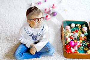 Beautiful kid boy and colorful vintage xmas toys and balls. Child decorating Christmas tree