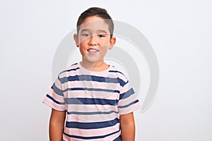 Beautiful kid boy wearing casual striped t-shirt standing over isolated white background with a happy and cool smile on face