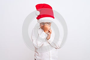 Beautiful kid boy wearing Christmas Santa hat standing over isolated white background tired rubbing nose and eyes feeling fatigue