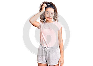 Beautiful kid girl with curly hair wearing casual clothes confuse and wonder about question