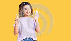 Beautiful kid girl with curly hair wearing casual clothes showing and pointing up with fingers number seven while smiling