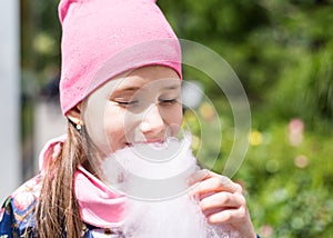 Beautiful kid girl with long hair in rose cap smiling outdoors.