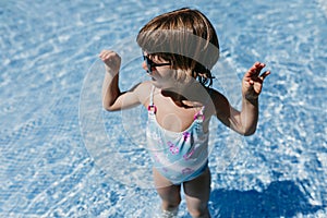 Beautiful kid girl at the pool wearing modern sunglasses. fun outdoors. Summertime and lifestyle concept