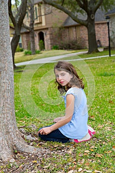 Beautiful kid girl smiling sitting on park lawn relaxed