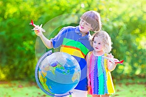 Beautiful kids playing with airplanes and globe