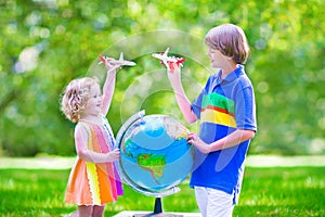 Beautiful kids playing with airplanes and globe