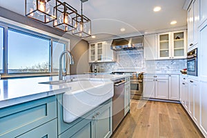 Beautiful kitchen room with green island and farm sink. photo