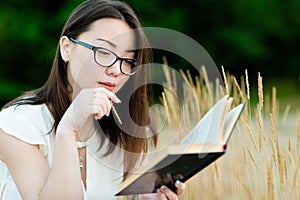 Beautiful korean girl reading book outdoors