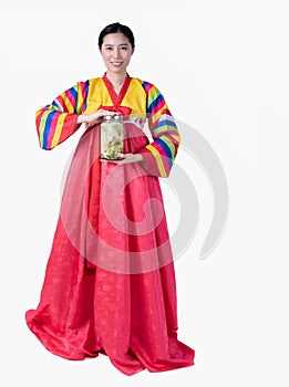 Beautiful Korean girl wearing traditional hanbok Hold a jar of fresh vegetables to ferment pickles. on a white background