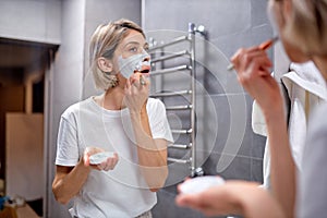 beautiful lady applying mask with brush on moisturized soft healthy sensitive skin
