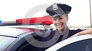 Beautiful lady cop in service cap smiling to camera, woman protecting city photo