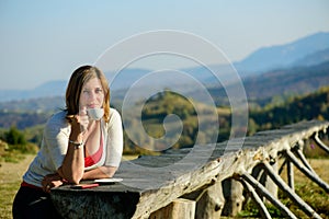 Beautiful lady drinking coffee. Mountain view