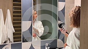 Beautiful lady drying her hair in the bathroom