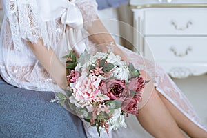 Beautiful lady in elegant white robe and bouquet