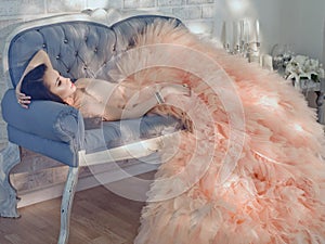 Beautiful lady in gorgeous couture dress on sofa