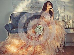 Beautiful lady in gorgeous couture dress on sofa