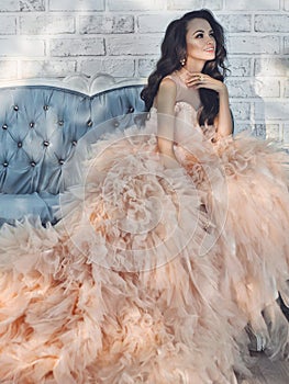 Beautiful lady in gorgeous couture dress on sofa