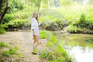 Beautiful lady in gumboots at river bank