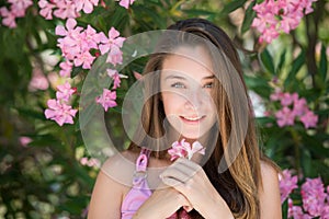 Beautiful lady in a headshot, holding and playing with a flower