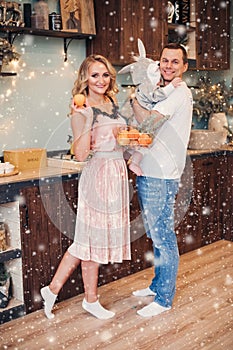 Beautiful lady with her child and husband in deocrated kitchen