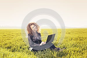 Beautiful lady with her laptop on grass